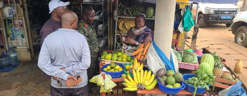 The Deputy Coordinator OWC Brig.Gen. GK Muwanguzi visits a PDM beneficiary Ms. Kendagano Imelda at her fresh foods stall.